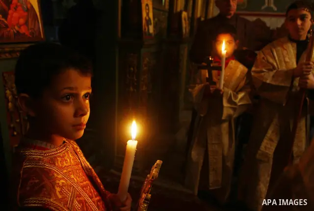 Palestinian Christian boys hold candles during a service in the Saint Porfirios church in Gaza City on Christmas day December 25, 2011. Photo by Ashraf Amra