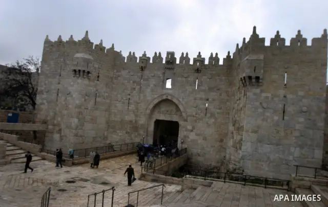 Palestinians walk outside Damascus Gate leading into the old city of Jerusalem from their way from prayer in the Al-Aqsa Mosque compound, Islam's third holiest site, on Dec 25, 2011. Photo by Mahfouz Abu Turk