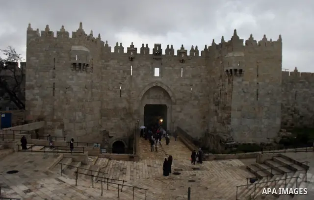 Palestinians walk outside Damascus Gate leading into the old city of Jerusalem from their way from prayer in the Al-Aqsa Mosque compound, Islam's third holiest site, on Dec 25, 2011. Photo by Mahfouz Abu Turk