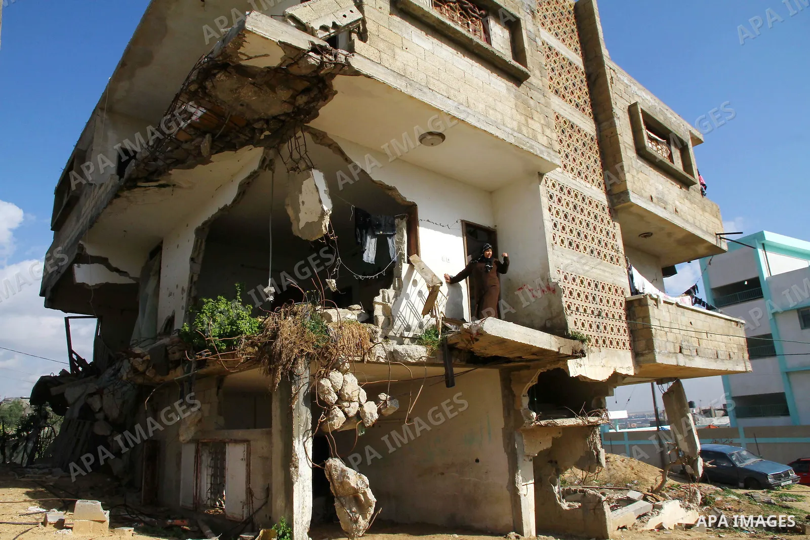 Palestinian woman stands in her house destroyed during the three-week offensive Israel launched before three years, in Gaza City, on 26 December 2011. which was damaged during Israel's three-week offensive three years ag...