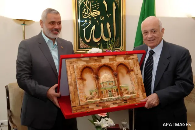 Palestinian premie minister of Gaza Strip Ismail Haniya (L) giving an artwork depicting Jerusalem's Dome of the Rock as a gift to Arab League secretary general Nabil al-Arabi during a meeting in Cairo on December 26, 201...