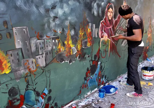 Palestinian Artists take part in paint a murals in the third anniversary of the Israeli war on Gaza Strip, in Gaza city on Dec. 27,2011. Photo by Mohammed Asad