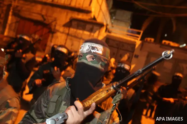 Masked Hamas militants march with their guns during a parade to mark the third anniversary of the Israeli offensive on Gaza in 2008, in Gaza City, Tuesday, Dec. 27, 2011. Palestinians mark the third anniversary of the th...
