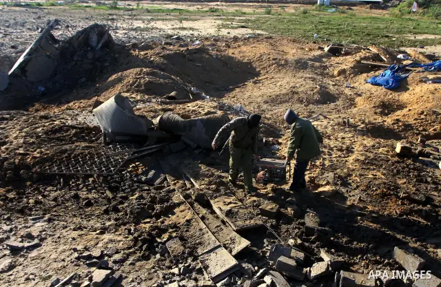 Palestinians survey an Islamic Jihad training camp damaged by an Israeli air strike in Gaza December 29, 2011. The Israeli army confirmed that it targeted two sites in Gaza, including the training camp, and added that th...