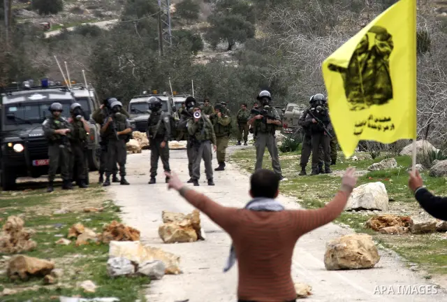 A Palestinian protester hurls stones at Israeli soldiers during a protest against the Jewish settlement of Qadomem, near the West Bank City of Nablus on 30 December 2011. Seven Palestinians were wounded during the clashe...