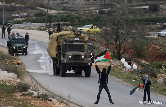 Palestinian protesters runs for cover from tear gas fired by Israeli soldiers during during demonstration against the expansion of the nearby Jewish settlement of Halamish in the West Bank village of Nabi Saleh near Rama...