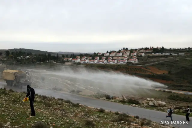 Palestinian protesters runs for cover from tear gas fired by Israeli soldiers during during demonstration against the expansion of the nearby Jewish settlement of Halamish in the West Bank village of Nabi Saleh near Rama...