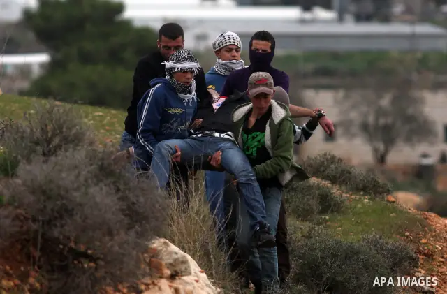 Palestinian protesters runs for cover from tear gas fired by Israeli soldiers during during demonstration against the expansion of the nearby Jewish settlement of Halamish in the West Bank village of Nabi Saleh near Rama...