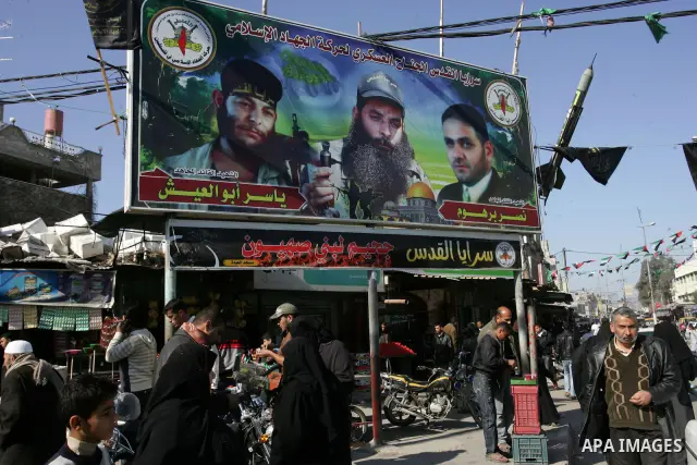 Palestinians walk in front of a billboard Hamas in Rafah refugee camp in the southern Gaza Strip on December 31, 2011.Photo by Abed Rahim Khatib