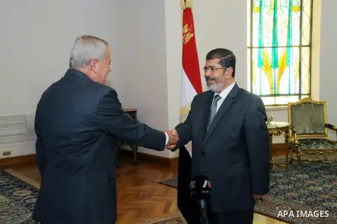Egypt's President Mohamed Mursi (R) shakes hands with Egypt's newly appointed Minister of State for Military Production Reda Mahmoud Hafez Abdel Maguid at the presidential palace in Cairo, August 13, 2012. Mursi has driv...