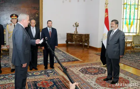 Egypt's President Mohamed Mursi (R) observes as Egypt's newly appointed Minister of State for Military Production Reda Mahmoud Hafez Abdel Maguid swears in at the presidential palace in Cairo, August 13, 2012. Mursi has...