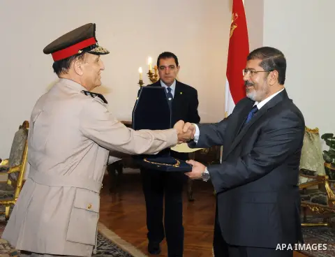 Former Armed Forces Chief of Staff Sami Anan, left, receives a high medal from Egyptian President Mohammed Morsi at the Presidential Palace in Cairo, Egypt, Tuesday, Aug. 14, 2012. Egypt's president has given awards to t...