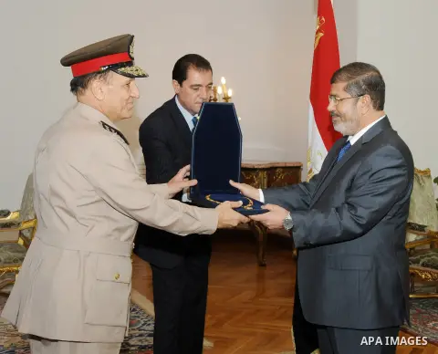 Former Armed Forces Chief of Staff Sami Anan, left, receives a high medal from Egyptian President Mohammed Morsi at the Presidential Palace in Cairo, Egypt, Tuesday, Aug. 14, 2012. Egypt's president has given awards to t...