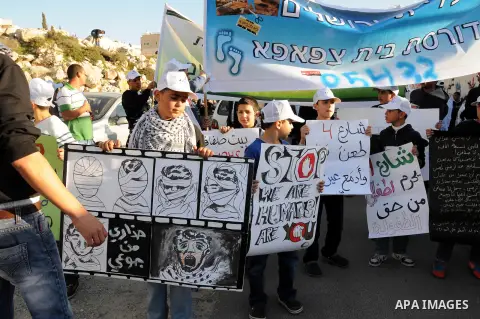 Palestinians take part in a protest against the opening project of the street number (4) in the middle of Bet Safafa neighbourhood, which is for settlement project services, in Jerusalem on February 26, 2013. Photo by Ma...