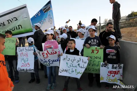 Palestinians take part in a protest against the opening project of the street number (4) in the middle of Bet Safafa neighbourhood, which is for settlement project services, in Jerusalem on February 26, 2013. Photo by Ma...