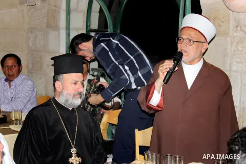 Palestinians of the National and religious leaders, Muslim and Christian attend the collective Iftar 'the evening meal during the Islamic month of Ramadan' to break their fasting in the Old City of Jerusalem, 16 July 201...