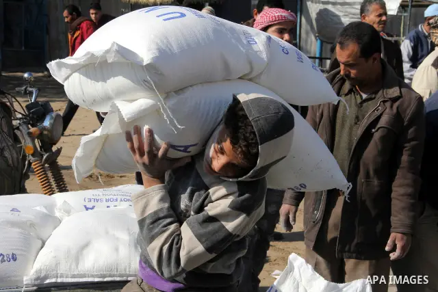 Palestinians collect food aid from the United Nations Relief and Works Agency (UNRWA) in the Rafah refugee camp, southern Gaza Strip, on Jan 04, 2012. Photo by Hatem Omar