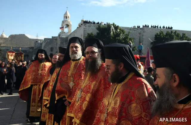 Greek Orthodox clergy lining up in Manger Square as the Christmas eve procession gets underway in the West Bank town of Bethlehem, 06 January 2012. Behind is the Church of the Nativity, traditionally accepted by all Chri...