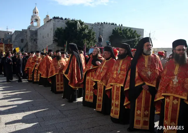 Greek Orthodox clergy lining up in Manger Square as the Christmas eve procession gets underway in the West Bank town of Bethlehem, 06 January 2012. Behind is the Church of the Nativity, traditionally accepted by all Chri...