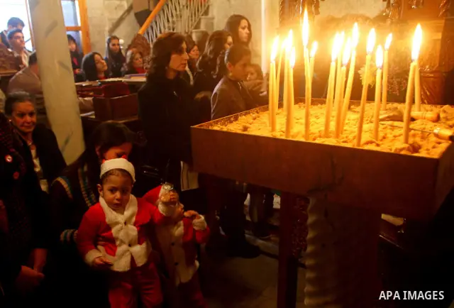 Palestinian Greek Orthodox Christians attend Christmas mass at the Orthodox Saint Porfirios church in Gaza City on January 7, 2012. The Orthodox Church celebrates Christmas and other religious holidays according to the J...