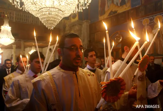 Palestinian Greek Orthodox Christians attend Christmas mass at the Orthodox Saint Porfirios church in Gaza City on January 7, 2012. The Orthodox Church celebrates Christmas and other religious holidays according to the J...
