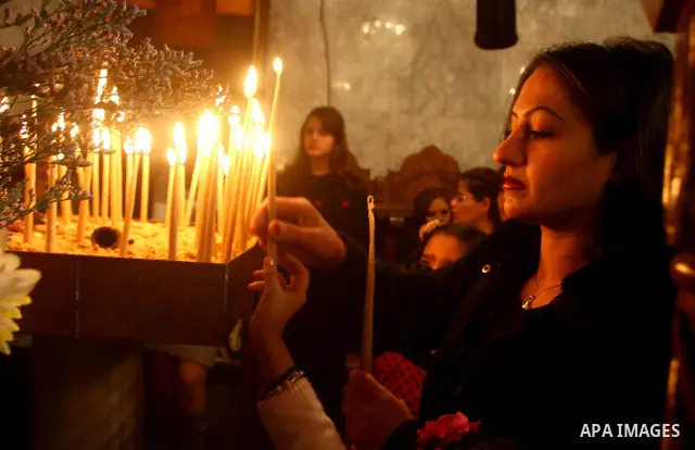 Palestinian Greek Orthodox Christians attend Christmas mass at the Orthodox Saint Porfirios church in Gaza City on January 7, 2012. The Orthodox Church celebrates Christmas and other religious holidays according to the J...