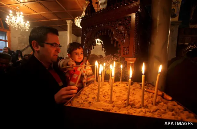 Palestinian Greek Orthodox Christians attend Christmas mass at the Orthodox Saint Porfirios church in Gaza City on January 7, 2012. The Orthodox Church celebrates Christmas and other religious holidays according to the J...