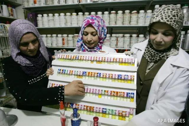 Palestinian women stand behind a counter in a small laboratory manufacturing perfumes to sell locally in the Rafah refugee camp in the southern Gaza Strip on January 8, 2012. A report released in October 2011 by the Worl...