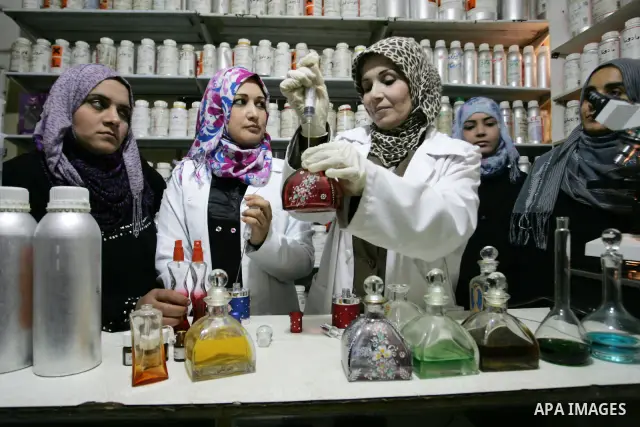 Palestinian women stand behind a counter in a small laboratory manufacturing perfumes to sell locally in the Rafah refugee camp in the southern Gaza Strip on January 8, 2012. A report released in October 2011 by the Worl...