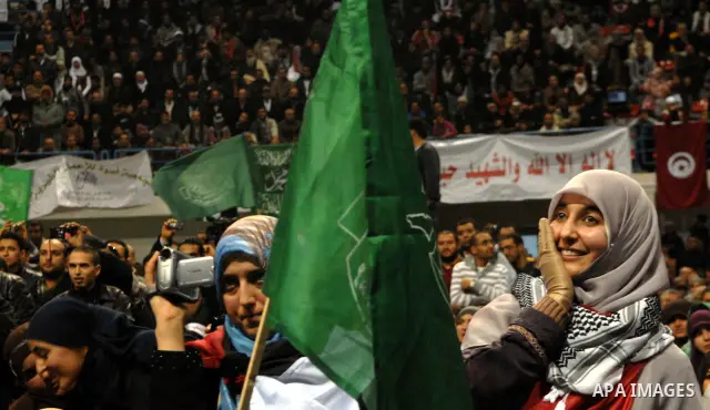 Supporters of the Tunisian islamist Ennahdha Party shout slogans and wave Palestinian flags during a speech delivered by Ismail Haniya, prime minister in the Hamas-ruled Gaza Strip, on January 8, 2012 in Tunis. A visit b...