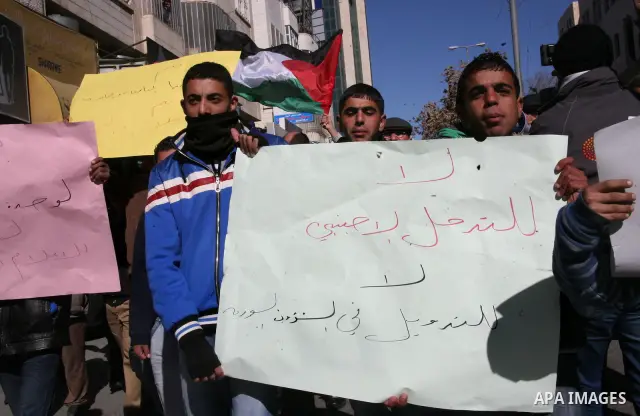 Palestinians hold Syrian flags and signs as they join a demonstration in support for the Syrian President Bashar al-Assad in the West Bank city of hebron on Jan 09, 2012. Photo by Mamoun Wazwaz
