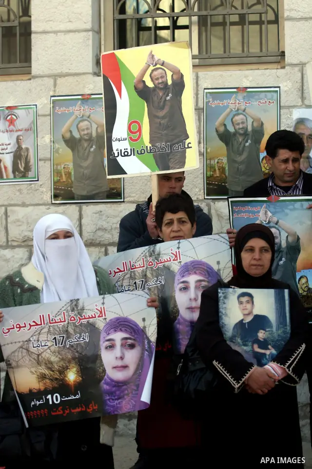 Palestinians hold up pictures of relatives held in Israeli jails during a protest calling for their release, in the West Bank city of Ramallah, on Jan. 10, 2012. Israel currently holds about 6600 Palestinians in its pris...