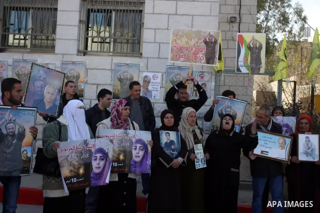 Palestinians hold up pictures of relatives held in Israeli jails during a protest calling for their release, in the West Bank city of Ramallah, on Jan. 10, 2012. Israel currently holds about 6600 Palestinians in its pris...