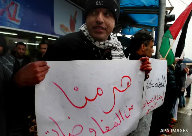 Palestinian activists hold banners during a protest the against peace talks in the West Bank city of Ramallah Saturday, Jan. 14, 2012. Palestinian and Israeli negotiators met last week for the first time in more than a y...