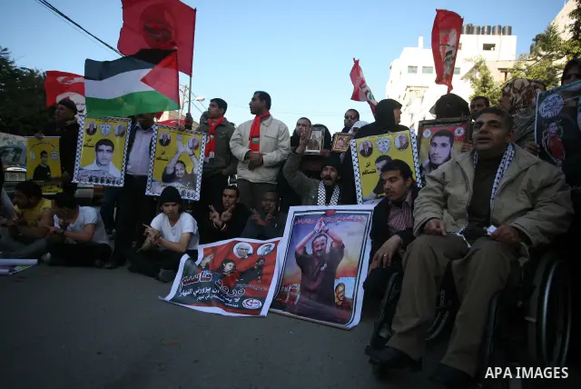 Palestinians man hold pictures of their prisoned relatives in Israeli jails as they gather in a weekly activity calling for their liberty at the Red Cross headquarters in Gaza City on Jan. 16, 2012. Photo by Mahmoud Nass...