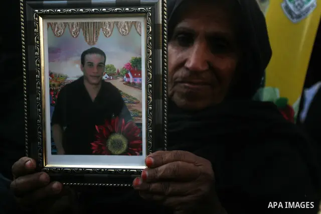 Palestinians woman hold pictures of their prisoned relatives in Israeli jails as they gather in a weekly activity calling for their liberty at the Red Cross headquarters in Gaza City on Jan. 16, 2012. Photo by Mahmoud Na...