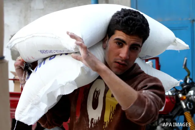 Palestinians receive their monthly food aid at a UN distribution center in the Shati refugee camp, in Gaza City, on January 17, 2012. The UN Agency for Palestinian Refugees (UNRWA) in Gaza launched an appeal for emergenc...