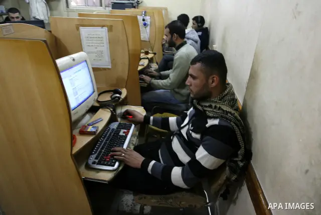 Palestinian man uses a computer as he looks at Visa cards on the web site in the southern Gaza Strip on January 18, 2012. The attacks were launched against Israeli sites at the beginning of this month when a Saudi intern...
