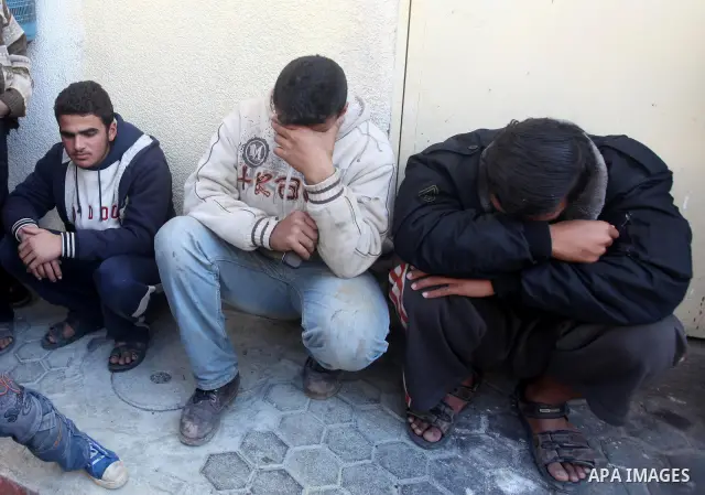 Palestinian men react upon the arrival of the body of Mohamed Abu Awda, after he was killed in an Israeli airstrike on northern Gaza on January 18, 2012. The raid hit a field used by Hamas in the east of the northern tow...