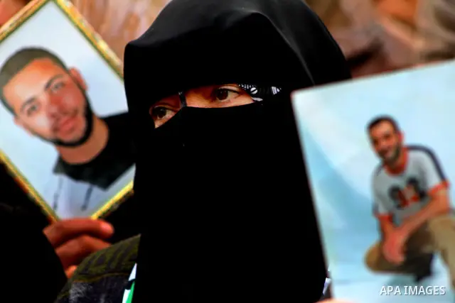 Palestinian women and children hold pictures of their prisoned relatives in Israeli jails as they gather in a protest calling for their liberty at the Red Cross headquarters in Gaza City on Jan. 19, 2012. Photo by Ashraf...