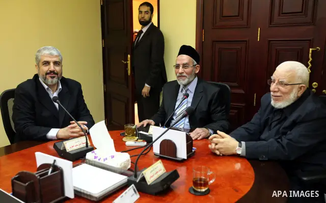 A handout photograph released by the Hamas Press Office shows Egyptian Mohamed Badie, leader of the Muslim Brotherhood greeting Palestinian Hamas leader Khaled Meshaal in Cairo, Egypt, 21 January 2012 . Photo by Mohammed...