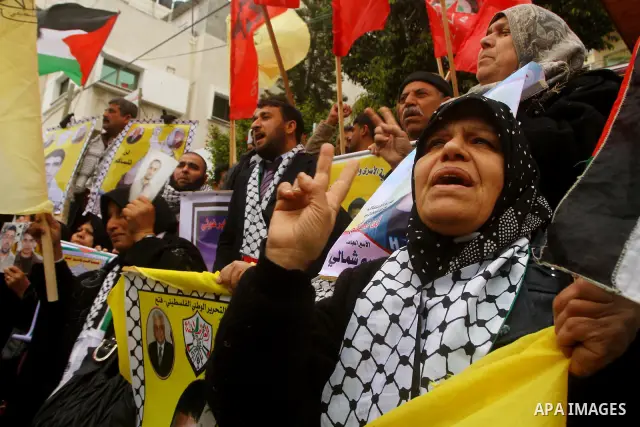 Palestinians man hold pictures of their prisoned relatives in Israeli jails as they gather in a weekly activity calling for their liberty at the Red Cross headquarters in Gaza City, on Jan. 23, 2012. Photo by Ashraf Amra