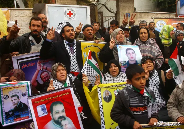 Palestinians man hold pictures of their prisoned relatives in Israeli jails as they gather in a weekly activity calling for their liberty at the Red Cross headquarters in Gaza City, on Jan. 23, 2012. Photo by Ashraf Amra