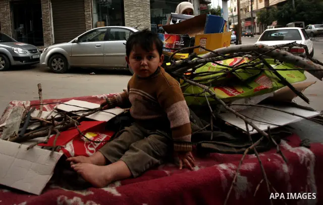 A Palestinian woman and her son use a donkey cart to collect wood and cartons for heating during cold winter days in Gaza city on Jan. 24,2012. Photo by Mahmud Nassar