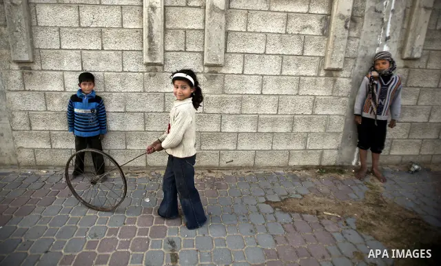 Palestinian children play between makeshift tents in one of the poorest regions in the Al-Zaiton neighbourhood, in the Gaza strip, on 24 January 2012. With high rates of unemployment and lack of work opportunities in Gaz...