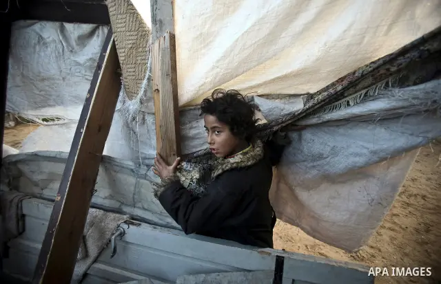 Palestinian children play between makeshift tents in one of the poorest regions in the Al-Zaiton neighbourhood, in the Gaza strip, on 24 January 2012. With high rates of unemployment and lack of work opportunities in Gaz...