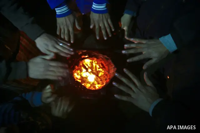 Palestinian people warm up by a fire during a cold winter night in their destroyed house, set up after the Israeli offensive on Gaza two years ago, in Jabaliya refugee camp in northren Gaza Strip on 23 January 2012. Phot...