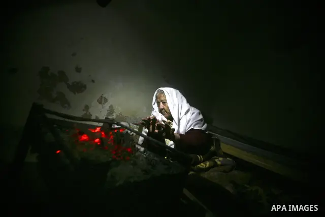 Palestinian people warm up by a fire during a cold winter night in their destroyed house, set up after the Israeli offensive on Gaza two years ago, in Jabaliya refugee camp in northren Gaza Strip on 23 January 2012. Phot...