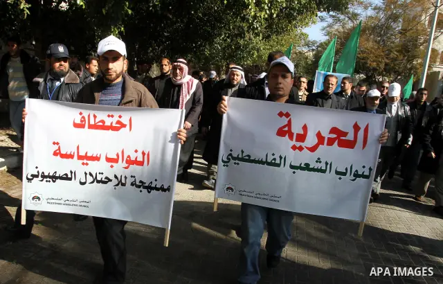 Palestinian men hold banners during a protest in Gaza City against Israel's arrest of Palestinian parliamentarians on January 25, 2012. Israeli police arrested on January 23, 2012 two senior Hamas officials -- former Pal...
