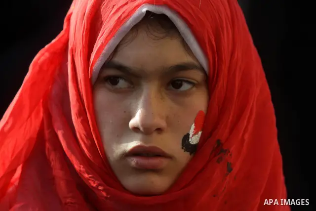 An Egyptian girl paints her face with the national flag during a protest to celebrate the one year anniversary of the 25th January uprising at Tahrir square in Cairo, Egypt, 25 January 2012. One year earlier the same day...